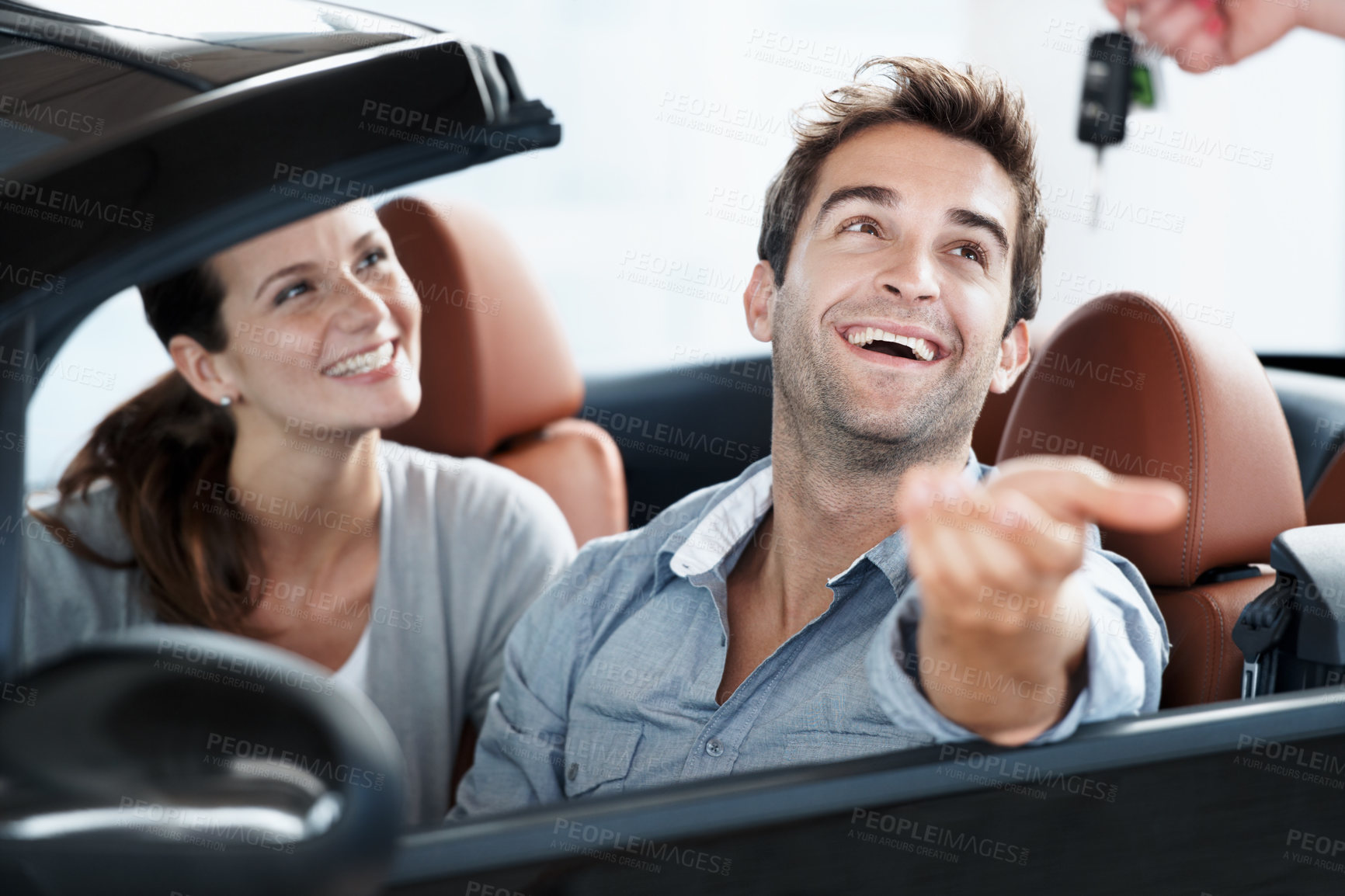 Buy stock photo Couple, laugh or key at car dealership with salesperson for purchase, sale or test drive in automobile. Man, woman and giving keychain in convertible for vehicle ownership, excited or transportation