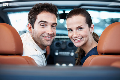 Buy stock photo Car dealership, couple and smile in convertible for decision, purchase or test drive. Back, portrait and satisfaction with happy people in showroom vehicle for consumerism, insurance or finance