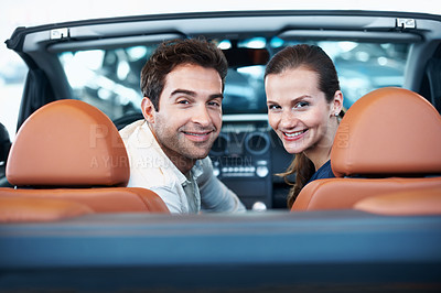 Buy stock photo Back, car dealership and portrait of couple in convertible for decision, purchase or test drive. Love, satisfaction and smile of happy people in showroom vehicle for consumerism, insurance or finance