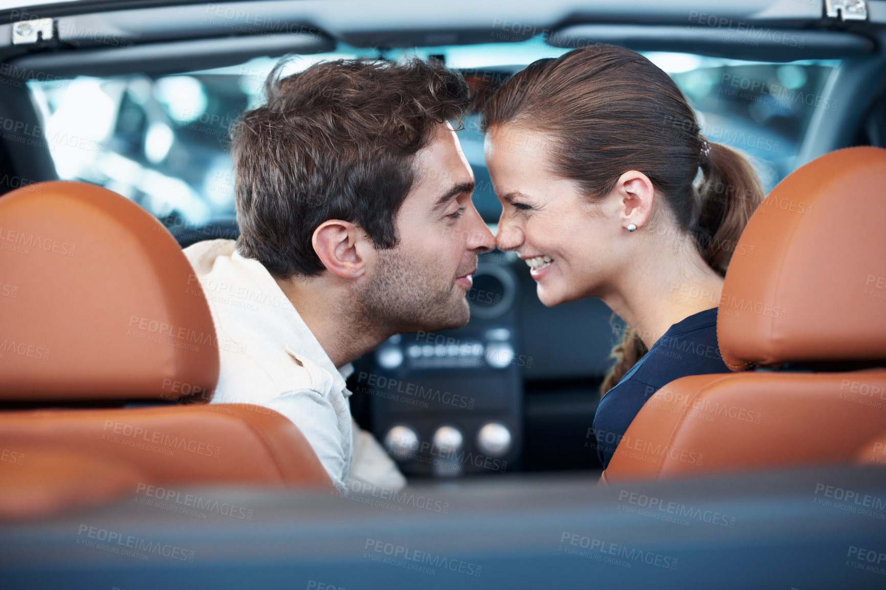 Buy stock photo Back, car dealership and couple laughing in convertible for decision, purchase or test drive. Love, funny and nose touch with happy people in showroom vehicle for consumerism, insurance or finance