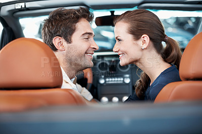 Buy stock photo Back, car dealership and couple in convertible for decision, purchase or test drive. Choice, love and satisfaction with happy people in showroom vehicle for consumerism, insurance or finance