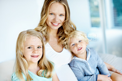 Buy stock photo Portrait of a pregnant mother with her little son and daughter sitting together at home