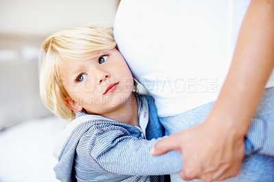 Buy stock photo A little boy with his arms around his mother's pregnant belly