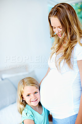 Buy stock photo Portrait of a little girl embracing her mother's pregnant belly