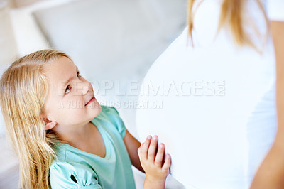 Buy stock photo Cropped image of a little girl holding her mother's pregnant belly