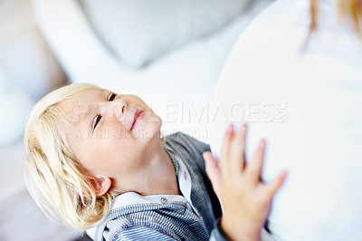 Buy stock photo A little boy with his hands on his mother's pregnant belly