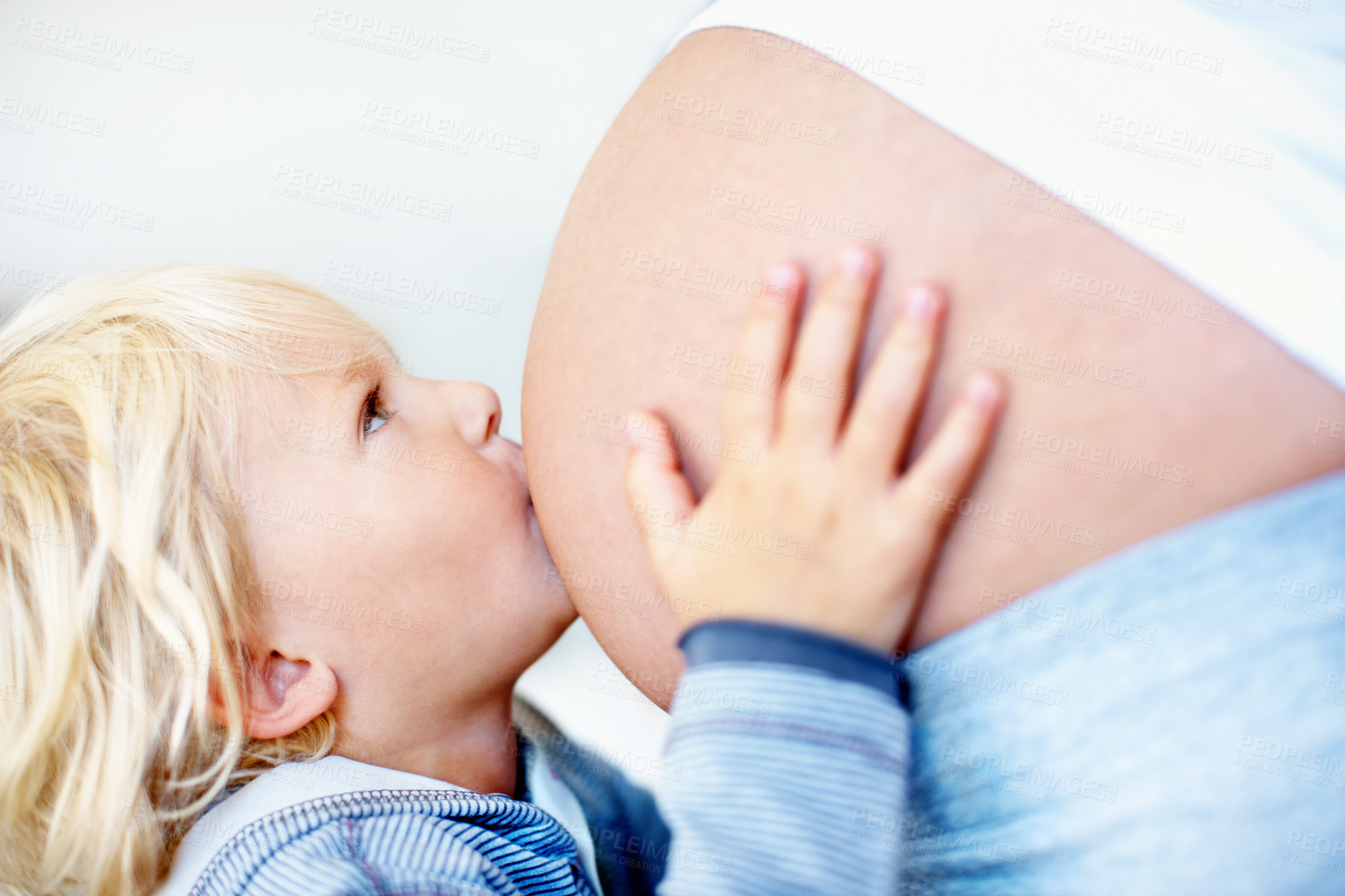 Buy stock photo Pregnancy, stomach and kiss with mother and son in home for bonding, support and connection. Prenatal growth, child development and security with pregnant woman and kid in apartment for family