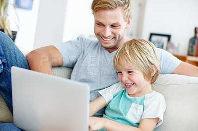Buy stock photo Handsome dad and his cute son enjoying playing on their laptop at home