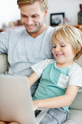 Buy stock photo Handsome dad and his cute son enjoying playing on their laptop at home