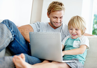 Buy stock photo Handsome dad and his cute son enjoying playing on their laptop at home