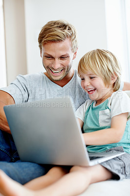 Buy stock photo Handsome dad and his cute son enjoying playing on their laptop at home