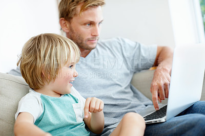 Buy stock photo Handsome dad and his cute son enjoying playing on their laptop at home
