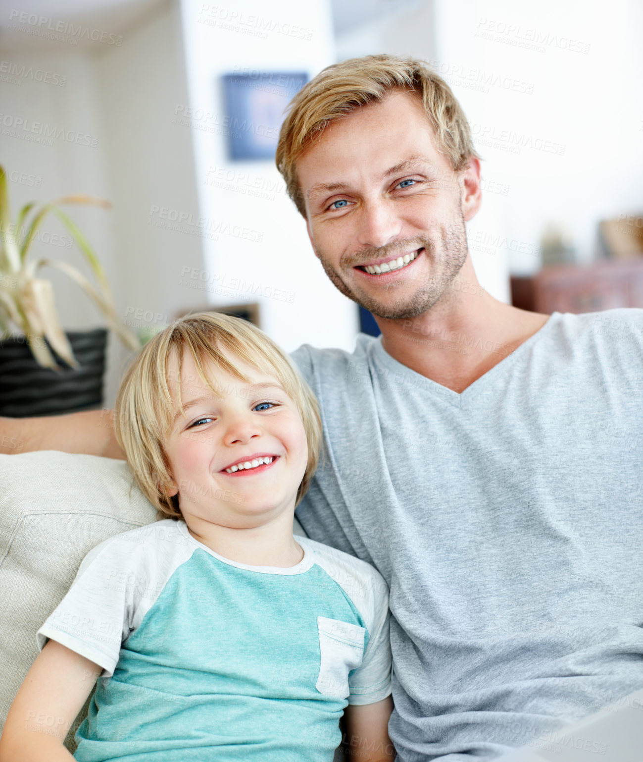 Buy stock photo Relax, smile and portrait of father and son on sofa in home for bonding, support and connection. Weekend break, happy and care with man and child in living room of family house for security and love