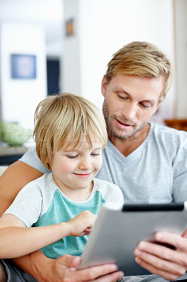 Buy stock photo Handsome dad teaching his cute little son to use their new digital tablet
