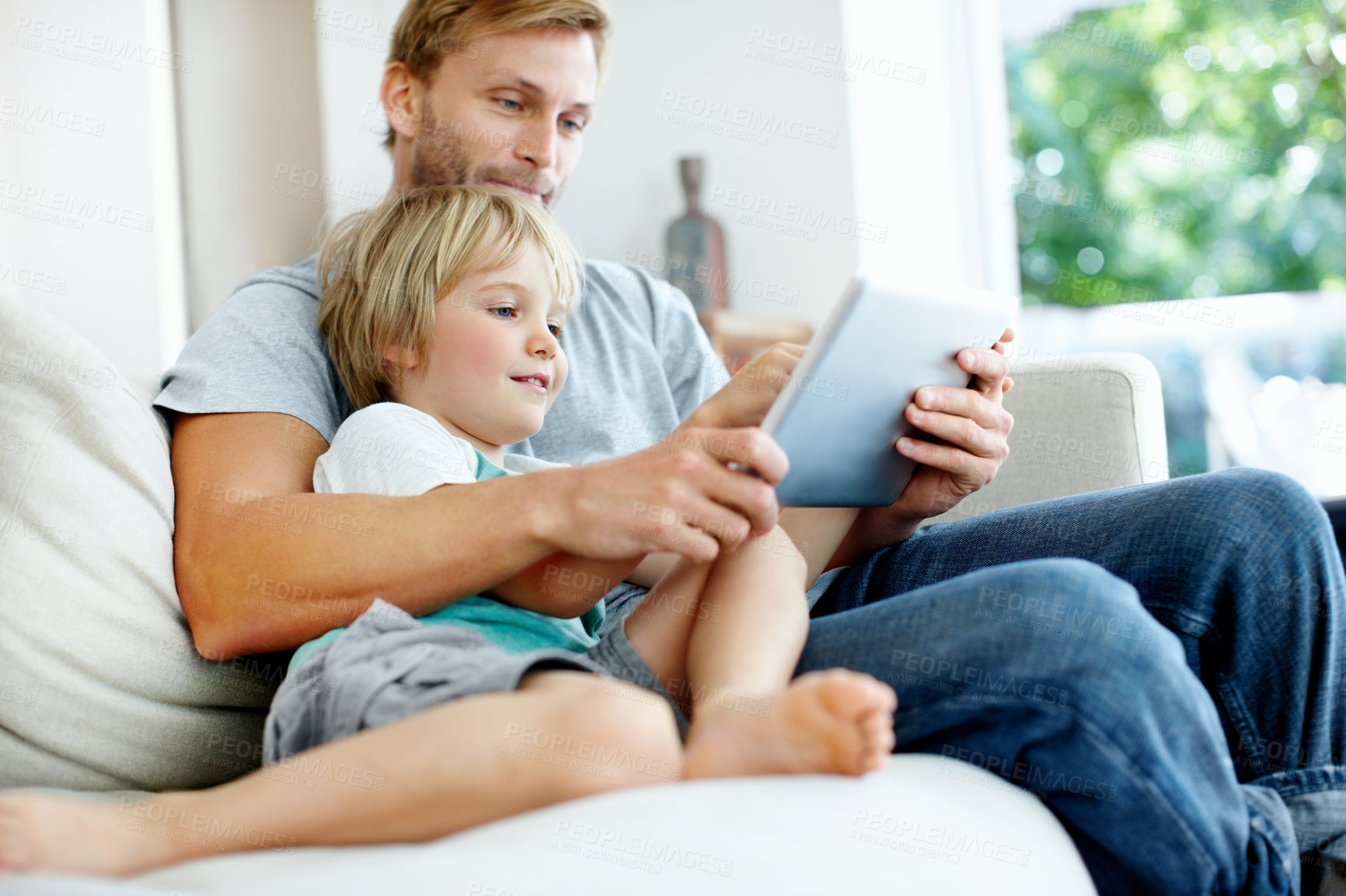 Buy stock photo Tablet, love and father with son on sofa in home for education app, smile or learning game. Search, child development website and subscription with man and kid in living room for bonding and relax
