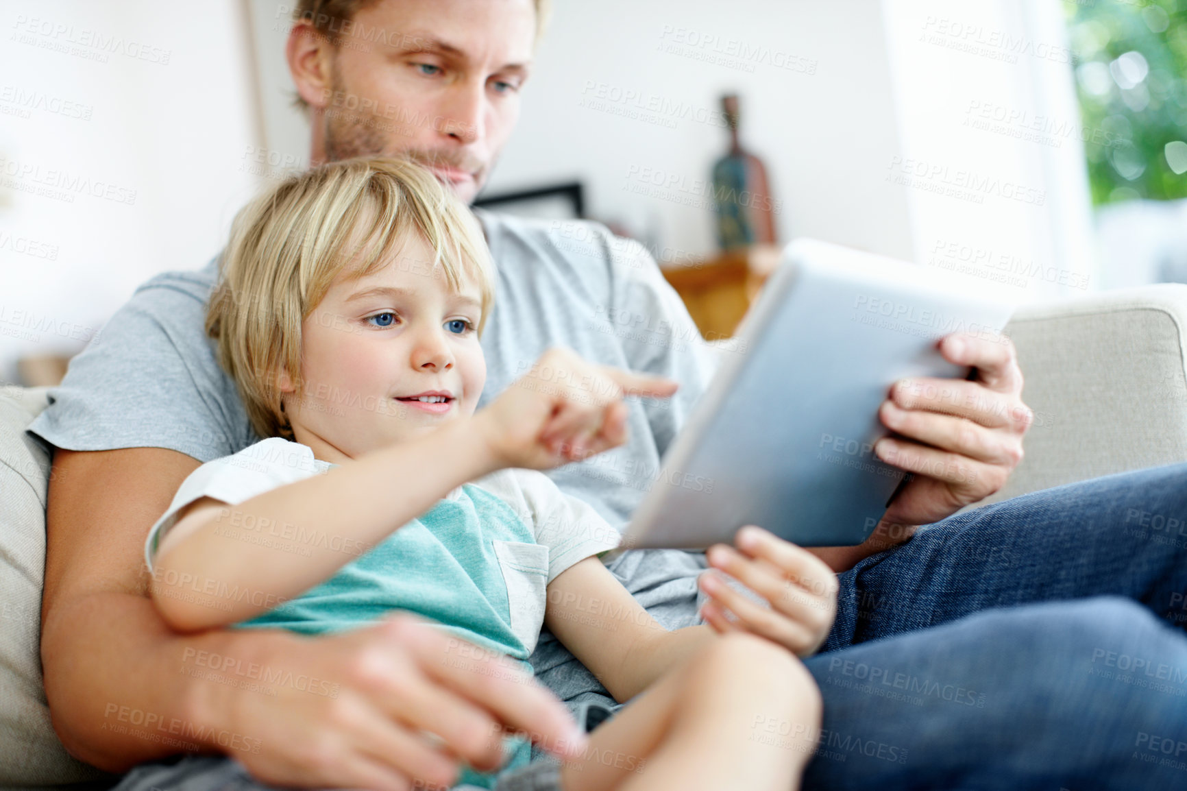 Buy stock photo Loving father and son on the couch using their digital tablet together