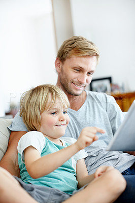 Buy stock photo Happy father and son on the couch using their digital tablet together