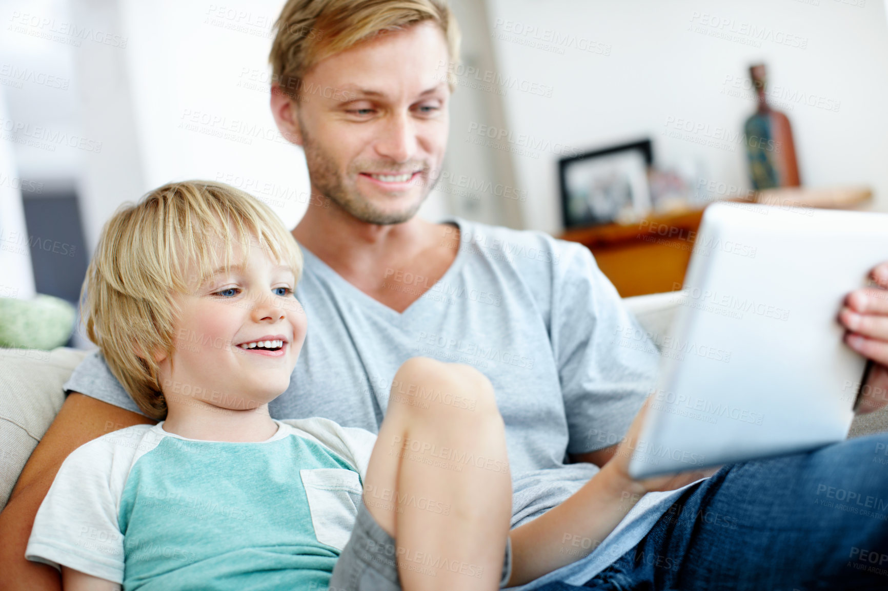 Buy stock photo Tablet, laughing and father with child on sofa in home for streaming service, cartoon and relax. Movie subscription platform, online media app and weekend break with dad and happy kid in living room
