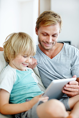Buy stock photo Happy father and son playing a game on a digital tablet at home