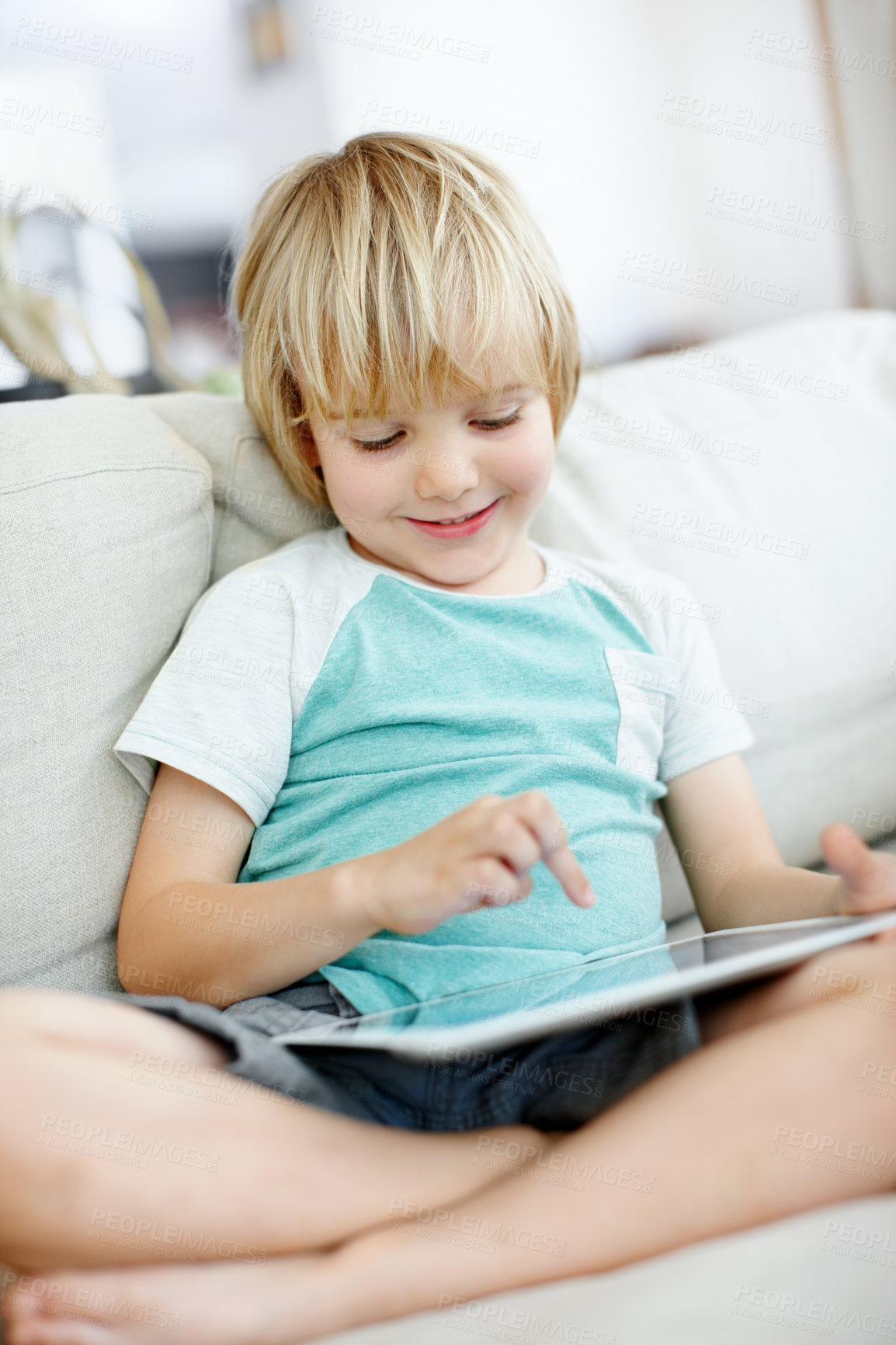 Buy stock photo Tablet, reading and relax with boy on sofa for education app, typing and learning game. Search, child development website and subscription with kid in living room of home for app and streaming