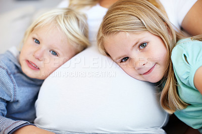 Buy stock photo Two young children listening to their pregnant mother's belly