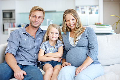 Buy stock photo Cute little girl sitting on the sofa with her father and pregnant mother