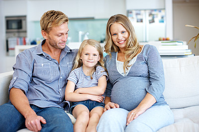 Buy stock photo Cute little girl sitting on the sofa with her father and pregnant mother