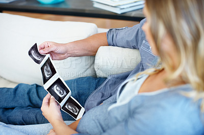 Buy stock photo Young couple looking at the ultrasound scan pictures of their unborn baby
