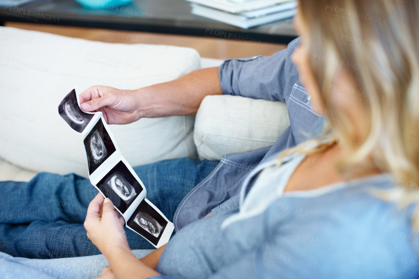 Buy stock photo Pregnancy, ultrasound and photo with couple on sofa for gender reveal, fetal growth and love. Family planning, baby development picture and sonogram with pregnant woman and man in living room of home