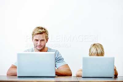 Buy stock photo A young father and his son sitting together on their laptops