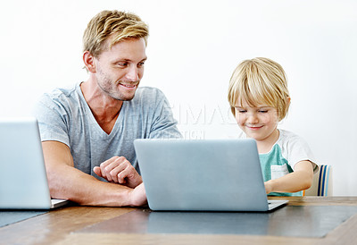 Buy stock photo A young father helping his son on his laptop