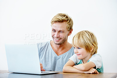 Buy stock photo A young father helping his little boy on his laptop