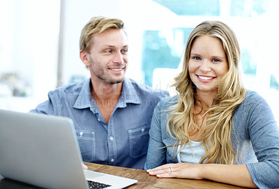 Buy stock photo Happy young couple using a laptop together at home