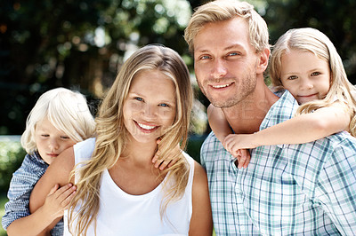 Buy stock photo A happy family of four smiling while outside in a garden - Portrait