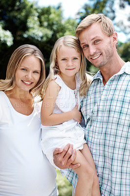 Buy stock photo A happy family of three smiling while outside in a garden - Portrait