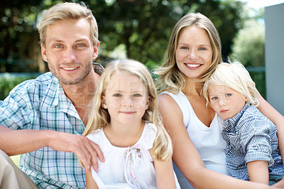 Buy stock photo A happy family of four smiling while outside in a garden - Portrait