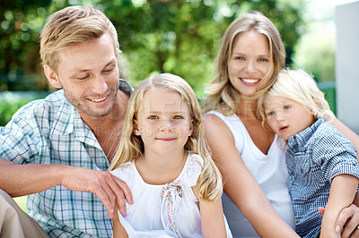Buy stock photo A happy family of four smiling while outside in a garden - Portrait