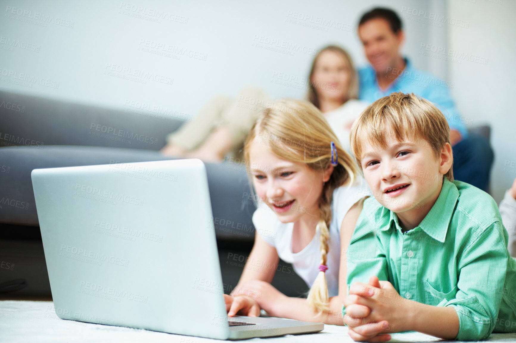 Buy stock photo Children, siblings and play in home with laptop, knowledge game or bonding with parents supervision. Portrait, kids relax and educational gaming in living room with computer, smile and entertainment.