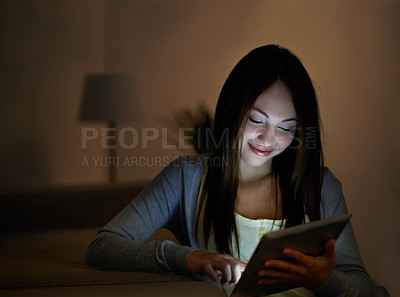 Buy stock photo A smiling teenager typing on her digital tablet