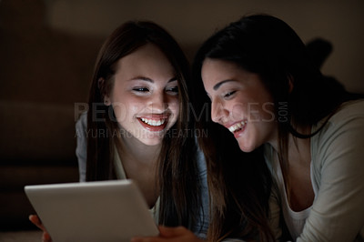 Buy stock photo Two teenage girls bonding while playing games on a digital tablet