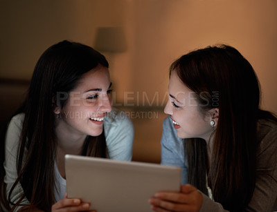 Buy stock photo Closeup of two teenage girls laughing about something on a digital tablet