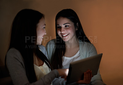 Buy stock photo Two teenage girls laughing and holding a digital tablet