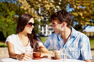 Buy stock photo Beautiful couple enjoying coffee at an outdoor cafe on a sunny day
