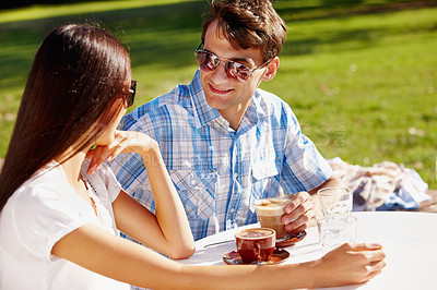 Buy stock photo Stylish young couple on a date at an outdoor cafe on a sunny day