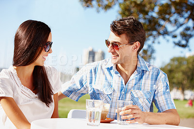 Buy stock photo Happy young couple enjoying coffee at an outdoor cafe on a sunny day