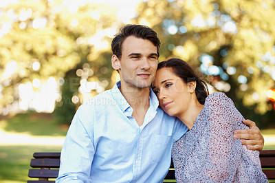 Buy stock photo Handsome young man looking away pensively with his beautiful girlfriend beside him in a sunny park