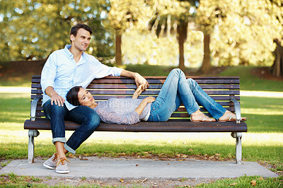 Buy stock photo Loving couple relaxing on a park bench on a sunny afternoon
