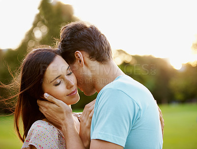 Buy stock photo Closeup of a beautiful woman being gently embraced by her boyfriend in a park