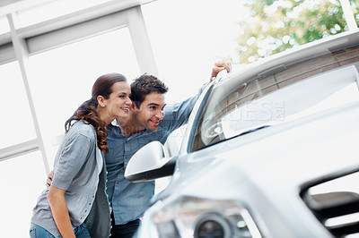 Buy stock photo Dealership, smile and couple check car, commerce and decision for automobile with partner. Showroom, man and woman with dream vehicle for purchase, shopping or happy customers with transport choice