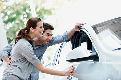 Buy stock photo Car, laughing and shopping with couple in dealership together for decision or purchase. Buying, retail and sale with funny people on showroom floor for consumerism, insurance or vehicle finance